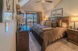 Experience luxury in this stunning bedroom featuring a cozy bed adorned with plush pillows and a warm, inviting comforter.