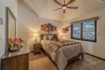 This cozy bedroom features a comfortable bed with a stylish faux fur throw and a charming Spiderman wall decor.