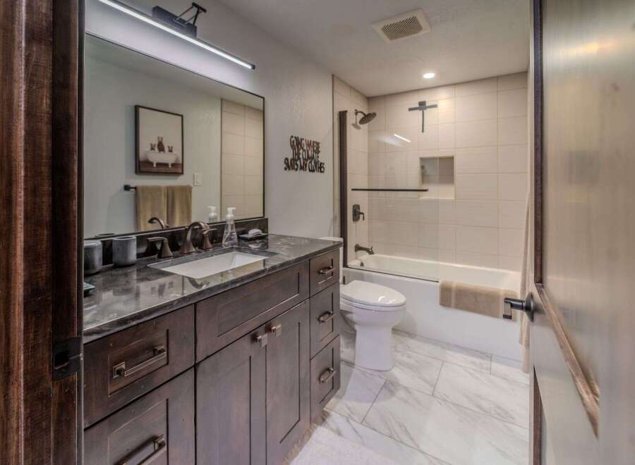 Step into luxury with this stunning bathroom, featuring a sleek vanity and a modern design.