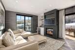 Experience luxury living in this stunning property featuring a cozy fireplace and a modern entertainment setup.