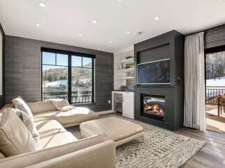 Experience luxury living in this stunning property featuring a cozy fireplace and a modern entertainment setup.