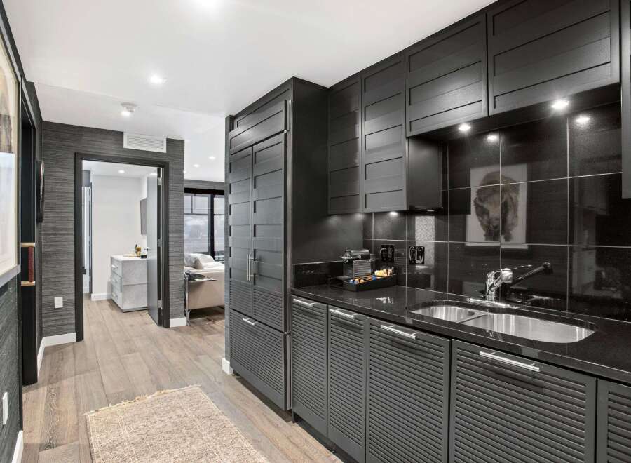 This stunning kitchen boasts sleek, modern design with dark cabinetry and countertops.