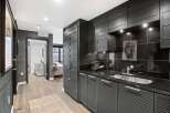 This stunning kitchen boasts sleek, modern design with dark cabinetry and countertops.