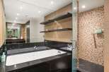 Indulge in luxury within this stunning bathroom, featuring a sleek black granite countertop and a pristine white bathtub.