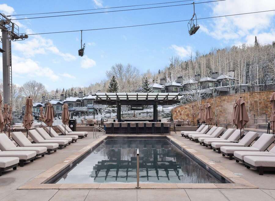 Enjoy a luxurious outdoor experience at this stunning property, featuring a heated pool and a stylish bar area.