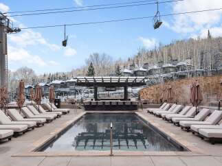 Enjoy a luxurious outdoor experience at this stunning property, featuring a heated pool and a stylish bar area.