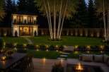 Experience luxurious outdoor living with this stunning backyard oasis, featuring a modern two-story home, a serene water feature, and a beautifully lit landscape.