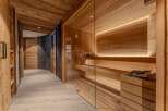 Experience ultimate relaxation in this luxurious spa area, featuring a modern glass-enclosed sauna with warm wood paneling and ambient lighting.