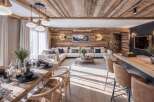 Experience luxurious mountain living in this stunning open-concept space, featuring a rustic wood-paneled ceiling and walls that create a warm, inviting ambiance.