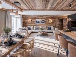 Experience luxurious mountain living in this stunning open-concept space, featuring a rustic wood-paneled ceiling and walls that create a warm, inviting ambiance.