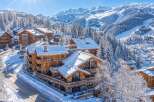 Experience luxury mountain living in this stunning chalet-style property nestled amidst snow-covered pine trees and majestic alpine peaks.
