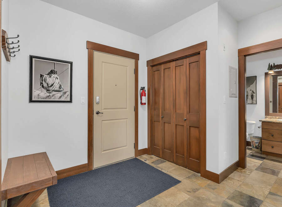 Step into this inviting entryway, featuring a neutral-toned door and a convenient closet.