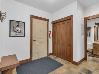 Step into this inviting entryway, featuring a neutral-toned door and a convenient closet.