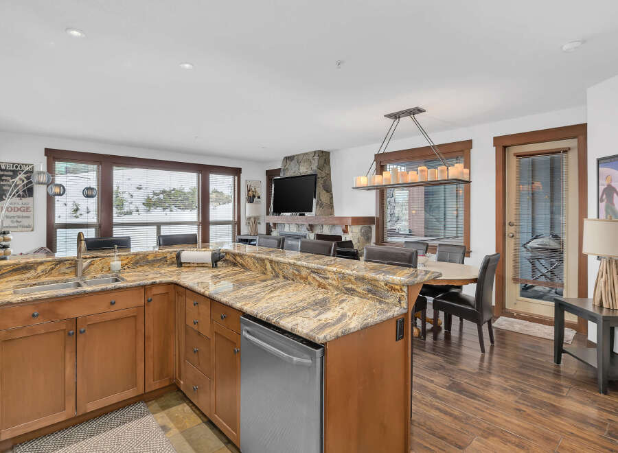 This stunning kitchen boasts a beautiful granite countertop and stainless steel appliances, perfect for preparing meals.