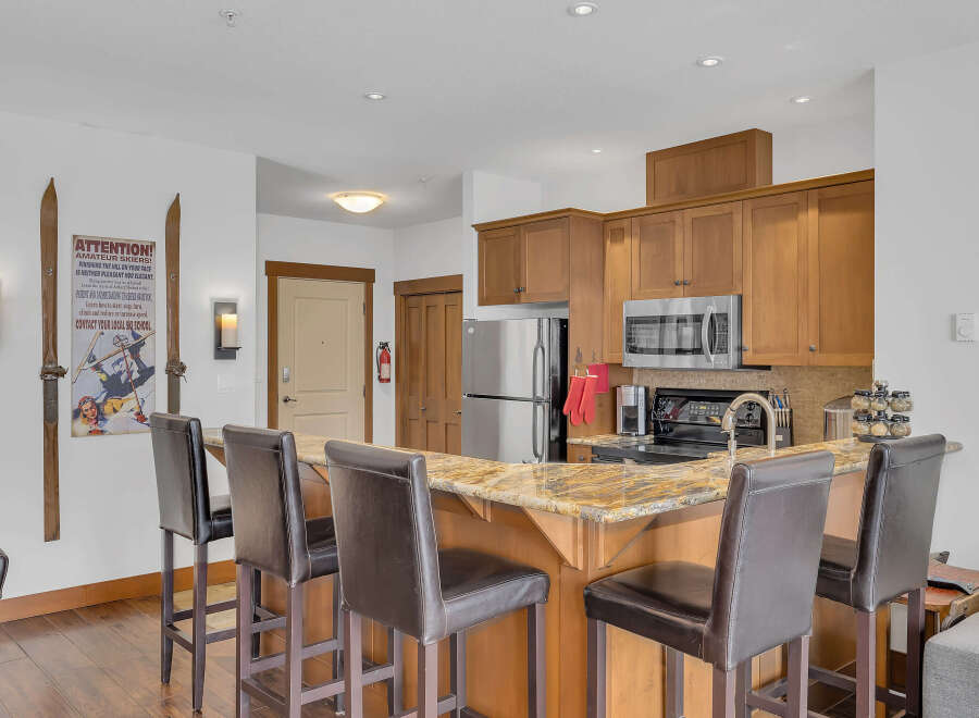 This stunning kitchen boasts a beautiful granite countertop and a breakfast bar with stylish seating, perfect for entertaining.