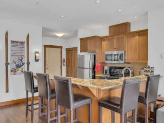 This stunning kitchen boasts a beautiful granite countertop and a breakfast bar with stylish seating, perfect for entertaining.