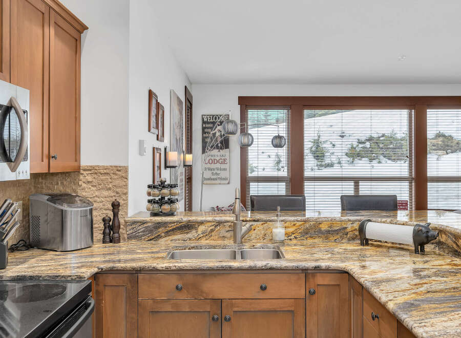 This stunning kitchen boasts beautiful granite countertops and custom cabinetry, creating an inviting space for culinary endeavors.