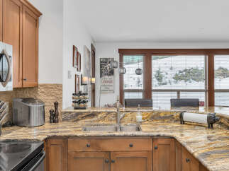This stunning kitchen boasts beautiful granite countertops and custom cabinetry, creating an inviting space for culinary endeavors.