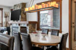 This stunning dining room features a beautiful stone fireplace and a large flat-screen TV, perfect for cozy evenings.