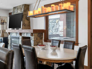 This stunning dining room features a beautiful stone fireplace and a large flat-screen TV, perfect for cozy evenings.
