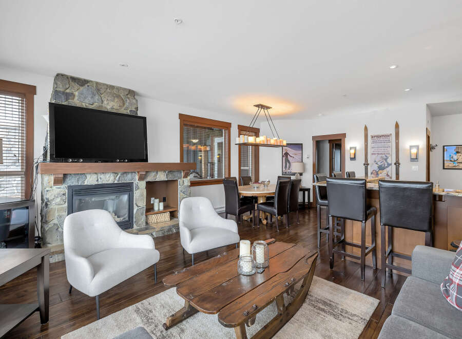 This stunning property boasts a cozy living room with a stone fireplace and a large flat-screen TV, perfect for relaxing evenings.