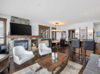 This stunning property boasts a cozy living room with a stone fireplace and a large flat-screen TV, perfect for relaxing evenings.