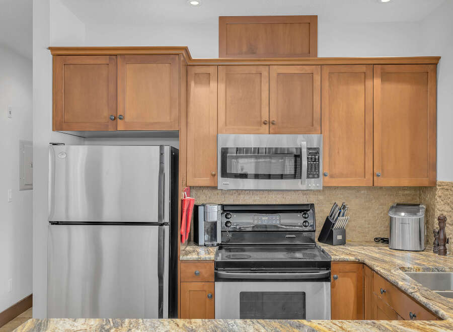 This stunning kitchen boasts stainless steel appliances, including a refrigerator, microwave, and oven.