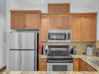 This stunning kitchen boasts stainless steel appliances, including a refrigerator, microwave, and oven.