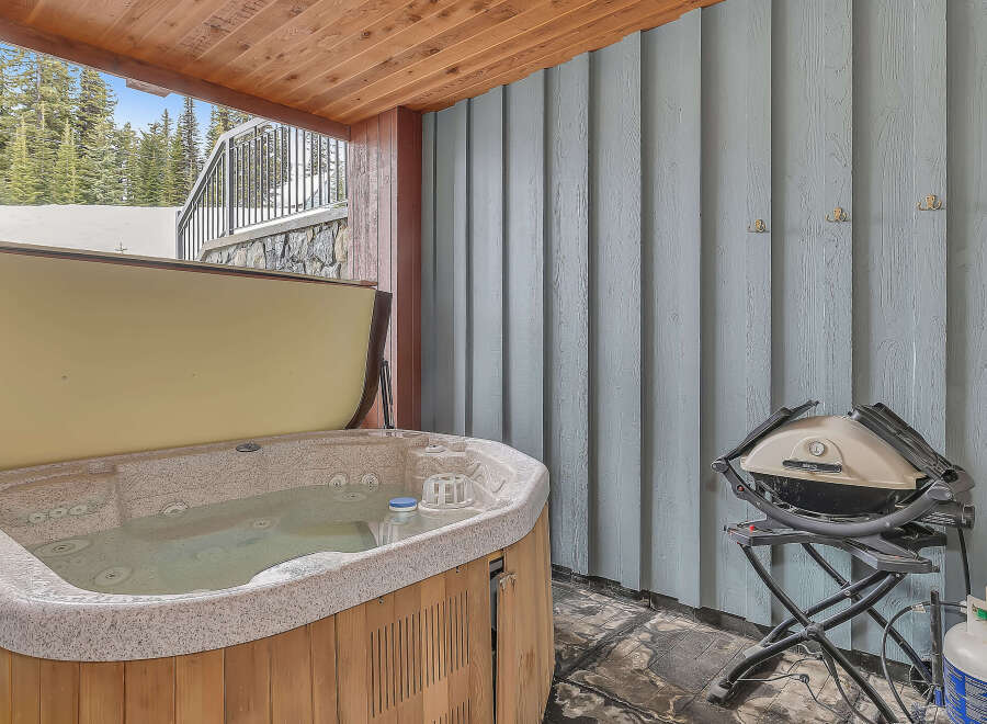 Relax and unwind in this luxurious outdoor space featuring a hot tub, perfect for soaking after a day on the slopes.