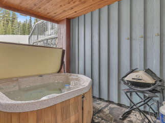 Relax and unwind in this luxurious outdoor space featuring a hot tub, perfect for soaking after a day on the slopes.