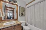 This charming bathroom features a stylish vanity with a granite countertop and a sleek, modern sink.