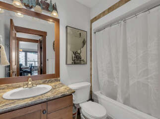 This charming bathroom features a stylish vanity with a granite countertop and a sleek, modern sink.