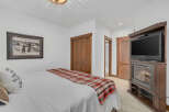This cozy bedroom features a comfortable bed with a stylish plaid throw and a decorative pillow.