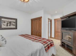 This cozy bedroom features a comfortable bed with a stylish plaid throw and a decorative pillow.
