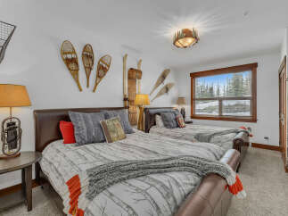This cozy bedroom features two comfortable beds with stylish bedding and decorative pillows.