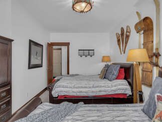 This cozy bedroom features a rustic ski lodge theme, perfect for a mountain getaway.