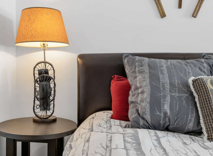 This cozy bedroom features a stylish bed with decorative pillows and a unique lamp.