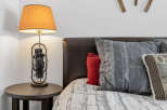 This cozy bedroom features a stylish bed with decorative pillows and a unique lamp.