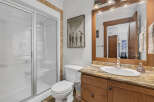 This stunning bathroom features a modern glass shower, a stylish vanity with a granite countertop, and a classic white toilet.