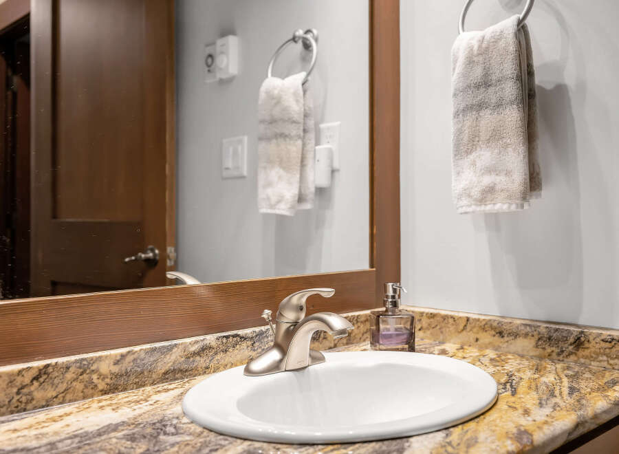 This stunning bathroom features a modern sink with a sleek faucet, complemented by a beautiful granite countertop.