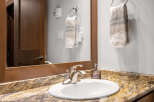 This stunning bathroom features a modern sink with a sleek faucet, complemented by a beautiful granite countertop.