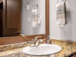 This stunning bathroom features a modern sink with a sleek faucet, complemented by a beautiful granite countertop.