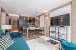 Discover modern living in this stylish apartment, featuring a sleek kitchen and a cozy living area.