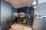 This modern kitchen boasts sleek, dark cabinetry and a minimalist design, perfect for contemporary living.