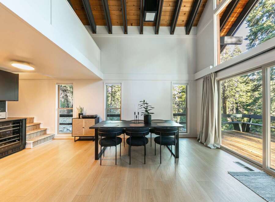 Experience modern living in this stunning property, featuring a spacious dining area with a sleek black table and chairs.