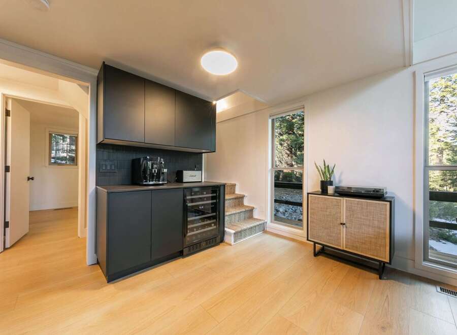 This stunning property boasts a modern interior with sleek black cabinetry and a built-in wine cooler, perfect for entertaining.