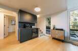 This stunning property boasts a modern interior with sleek black cabinetry and a built-in wine cooler, perfect for entertaining.