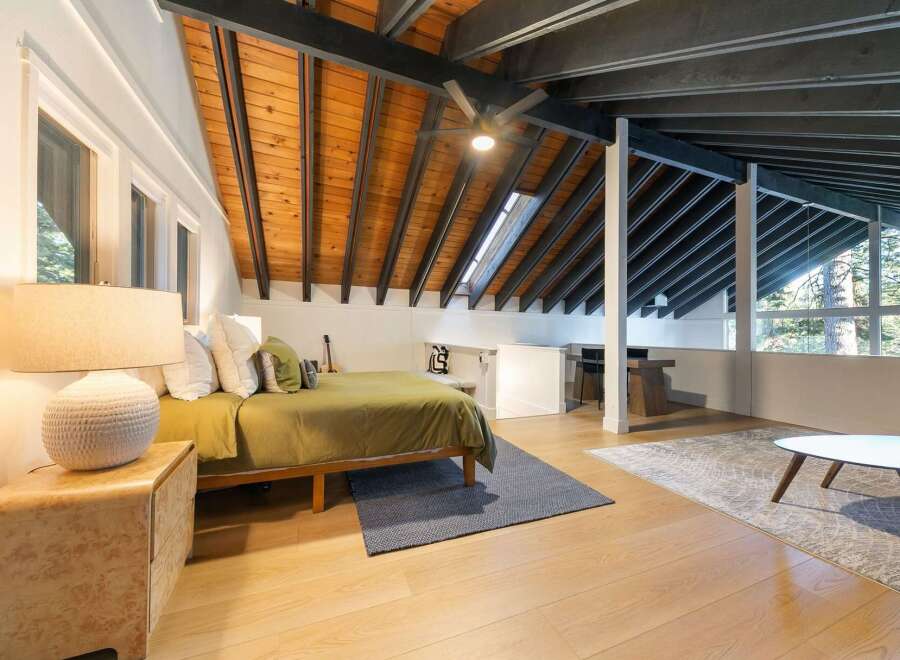 Discover the charm of this stunning bedroom featuring a unique sloped ceiling with exposed wooden beams, creating a warm and inviting atmosphere.
