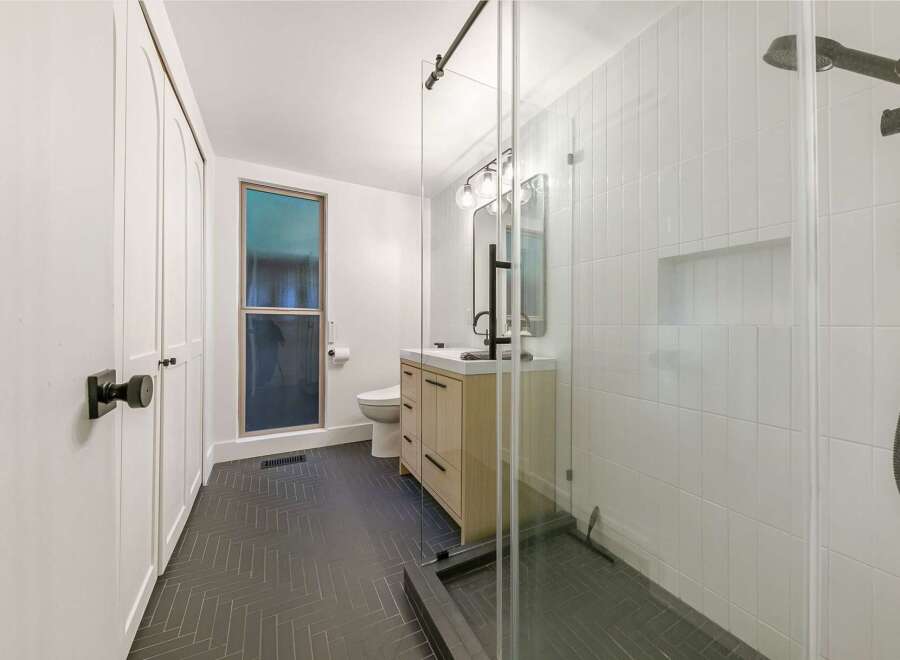 Step into a modern bathroom oasis! This stunning space features a sleek glass shower, a stylish vanity, and elegant tile work.