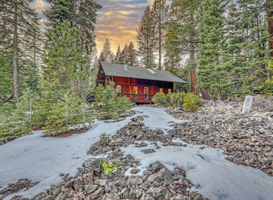 Nestled amidst towering trees and a serene landscape, this charming cabin offers a perfect blend of rustic charm and modern comfort.